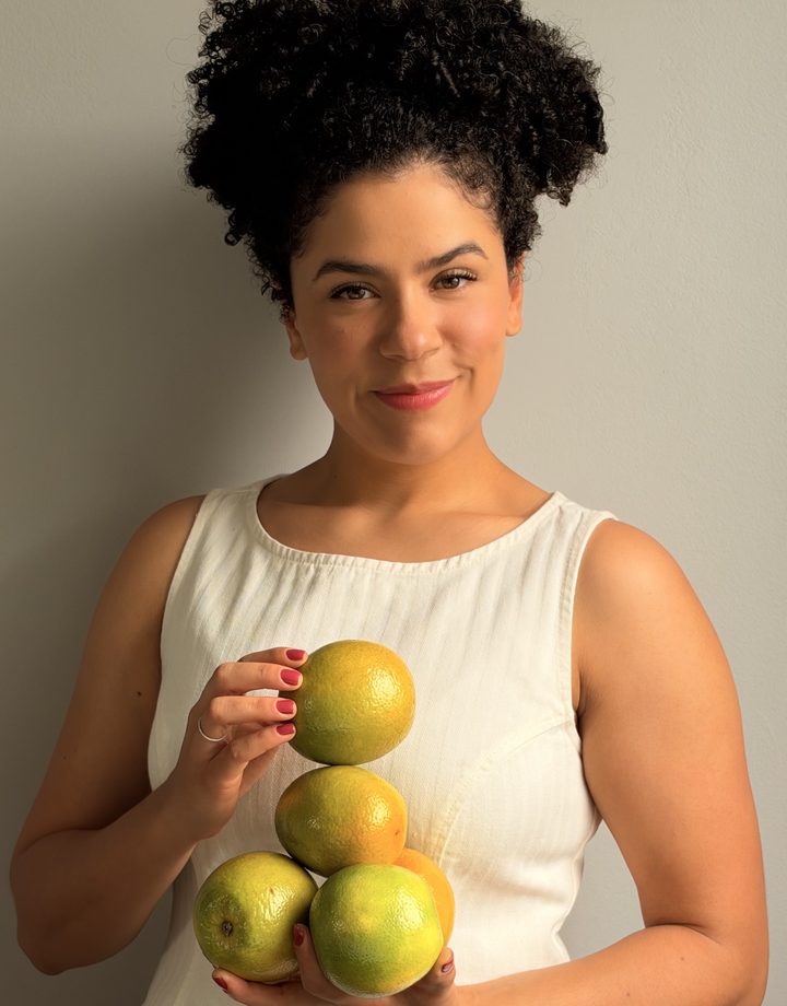 Amanda Mendes segurando laranjas e frutas